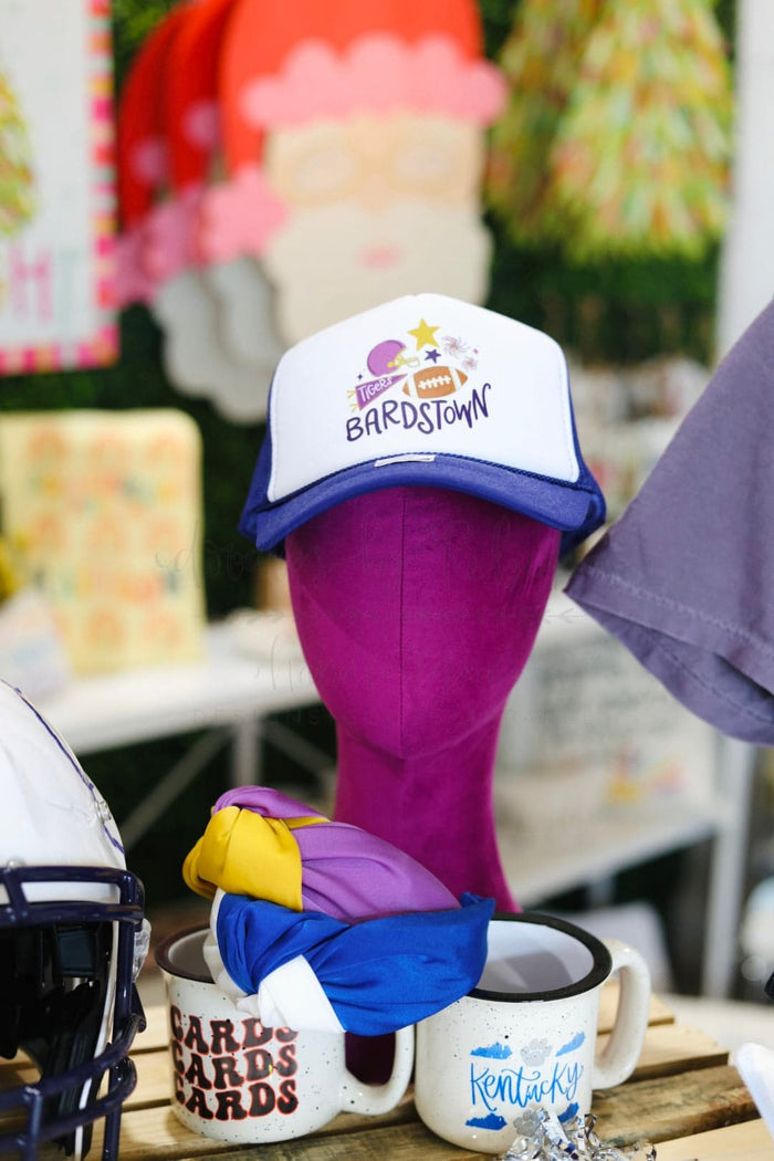 A 'Bardstown Tigers' trucker hat displayed on a mannequin head, with the hat's brim facing forward. The hat is primarily purple with a star graphic and the text 'BARDSTOWN' on the front.