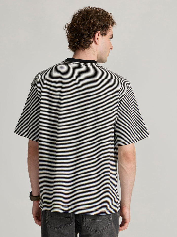 Man wearing a white and black striped crew t-shirt