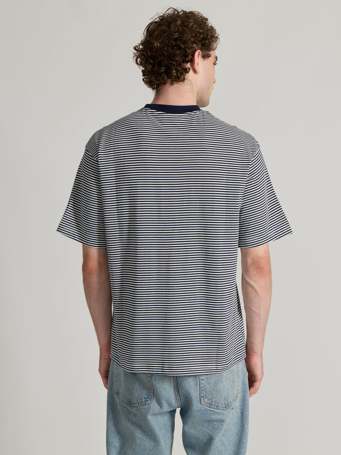 Man wearing a navy blue striped crew t-shirt