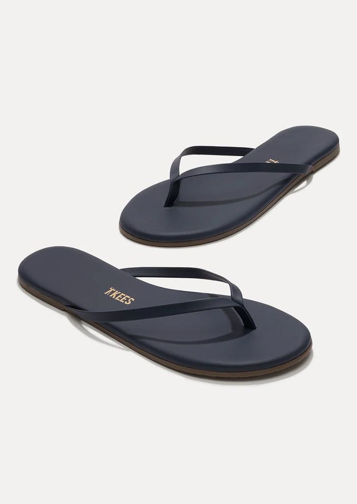 A pair of leather skinny strap TKEES sandals in dark navy.