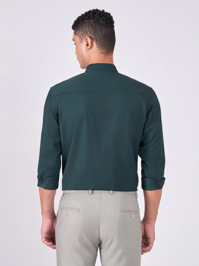 Man wearing Tencel prussian blue shirt and light gray pants on a white background