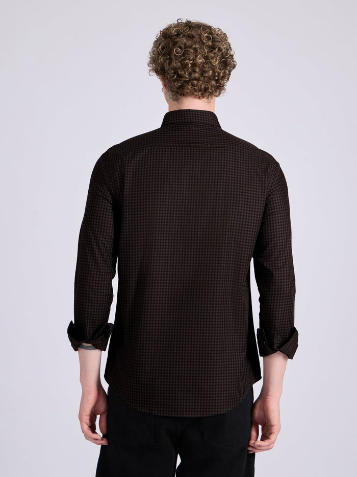 Man wearing a dark brown micro checkered shirt .