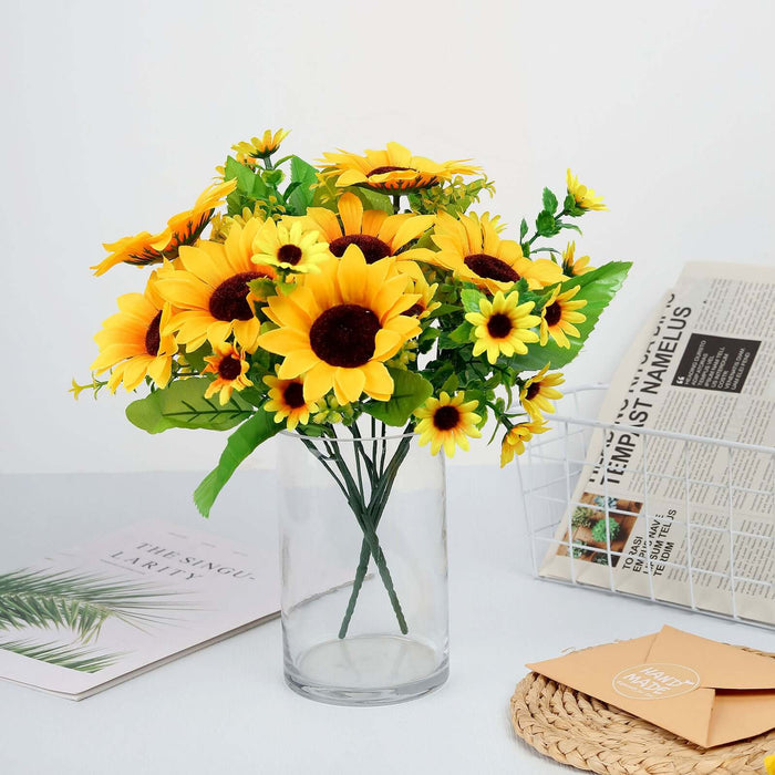 Artificial sunflower bouquet in a glass vase on a table.