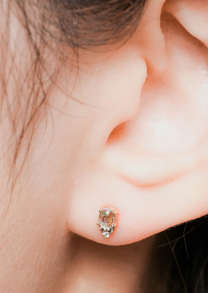 A pair of small aquamarine stud earrings in gold with crystal detail.