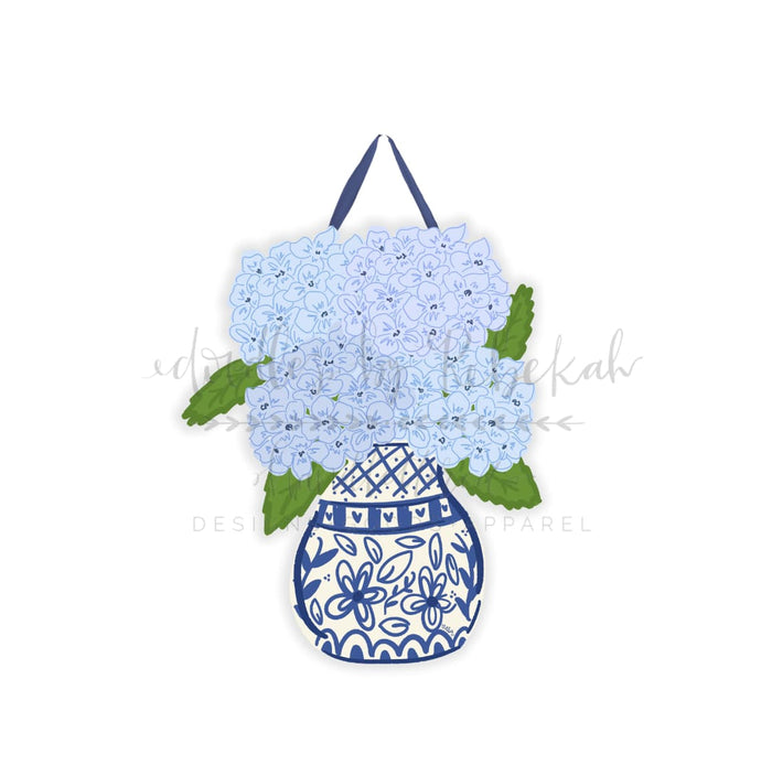 A doorhanger featuring a handcrafted blue hydrangea design with a matching ribbon hanger, displayed against a white background.