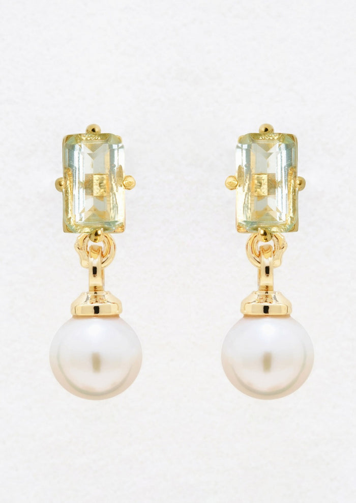 A pair of gold studs with baguette blue topaz and dangling pearl.