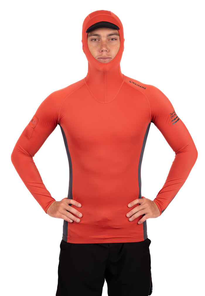 Male model wearing the Waihana Canyon Hooded Voyager Rashguard in orange-red with grey side panels and integrated hood, shown from the front against a white background.