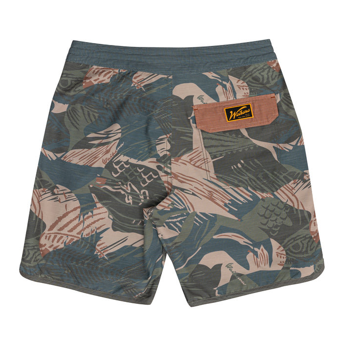 Rear view of Waihana Hawaiian Brushstroke Cruiser board shorts with a tropical camo pattern in olive, slate blue, and tan tones, featuring a branded woven patch on the back pocket.