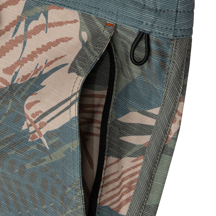 Close-up of the zippered side pocket with a black zipper pull loop on Waihana Hawaiian Brushstroke Cruiser Board Shorts in a teal, beige, and rust tropical print.