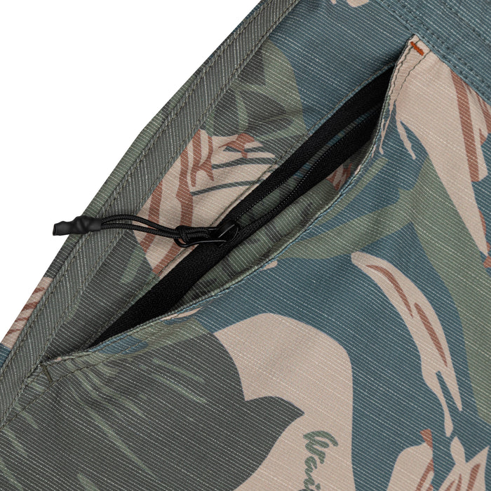 Close-up of a black zippered side pocket on Waihana Hawaiian Brushstroke Cruiser Shorts, highlighting the teal, sage, and tan tropical brushstroke print fabric.