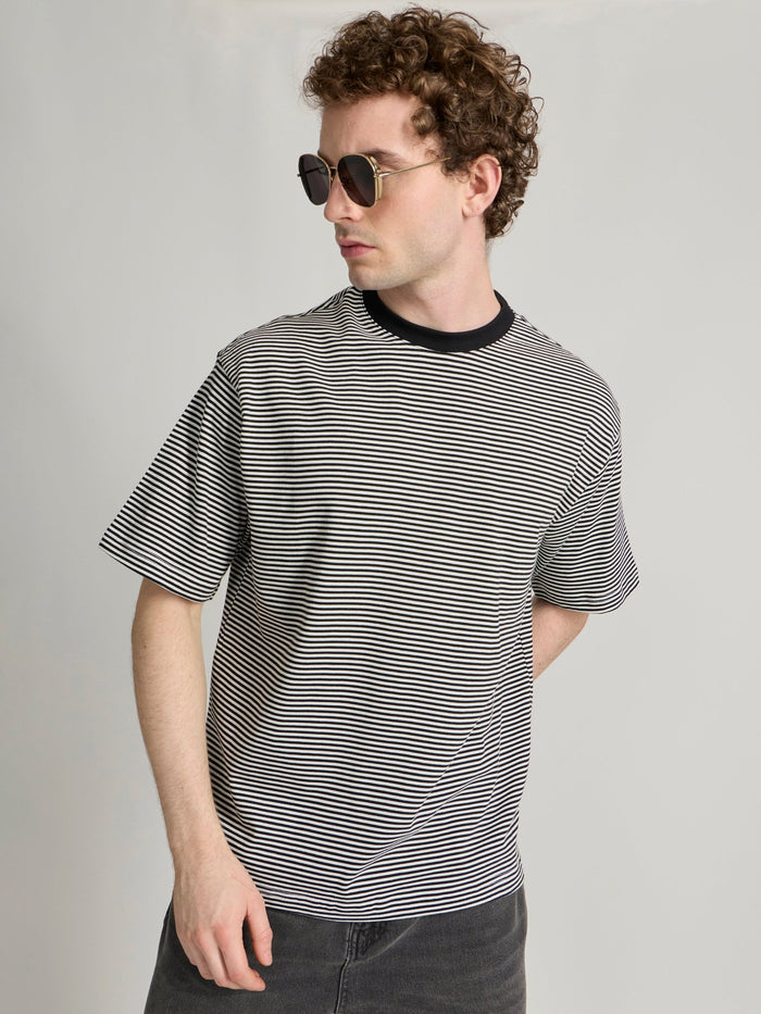 Man wearing a white and black striped crew t-shirt
