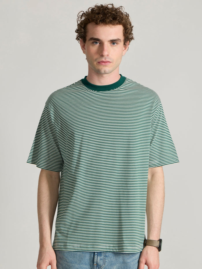 Man wearing a green  and white striped crew t-shirt