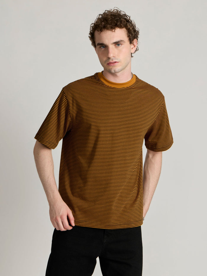 Man wearing a mustard yellow and black striped crew t-shirt