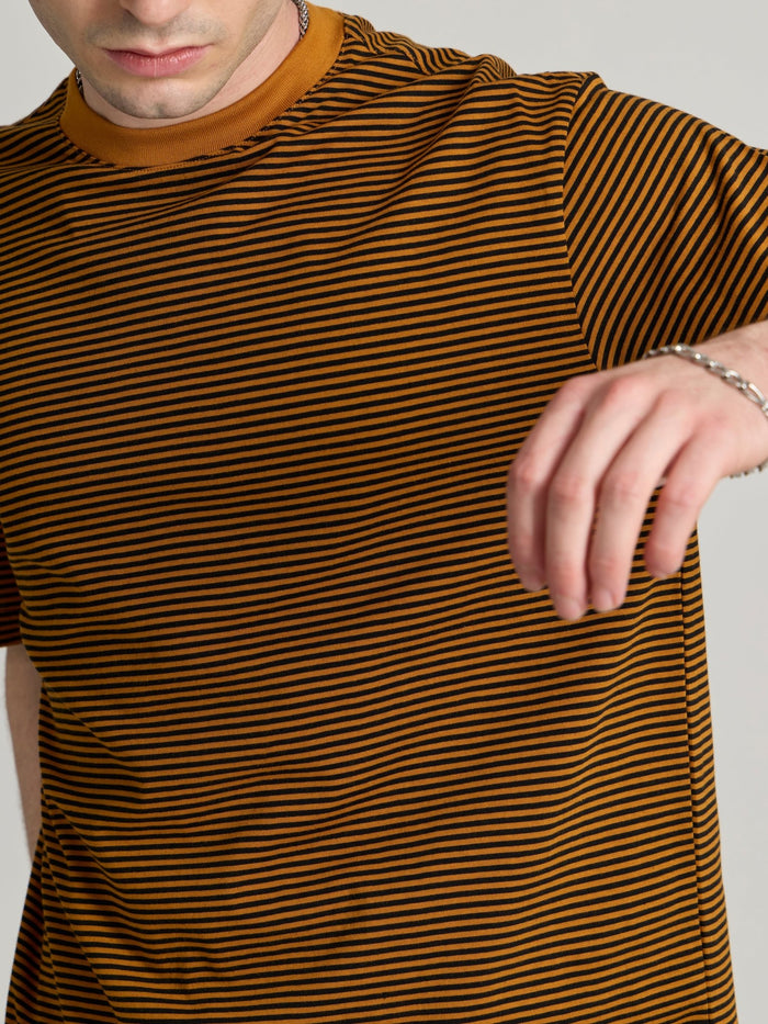 Man wearing a mustard yellow and black striped crew t-shirt