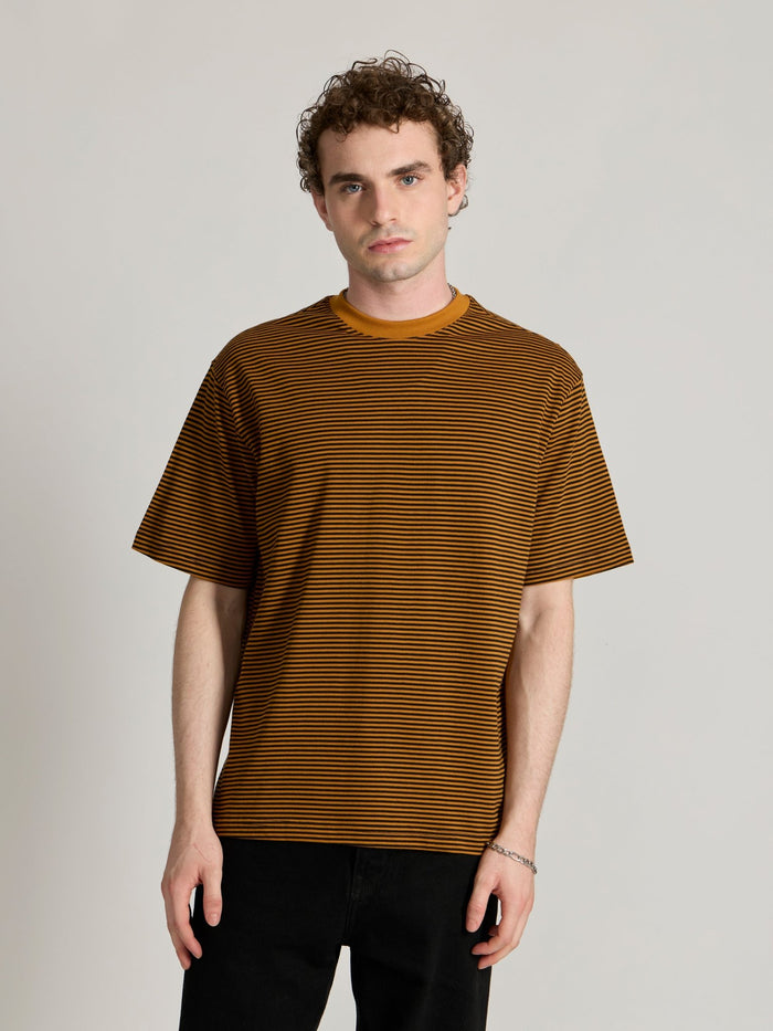 Man wearing a mustard yellow and black striped crew t-shirt