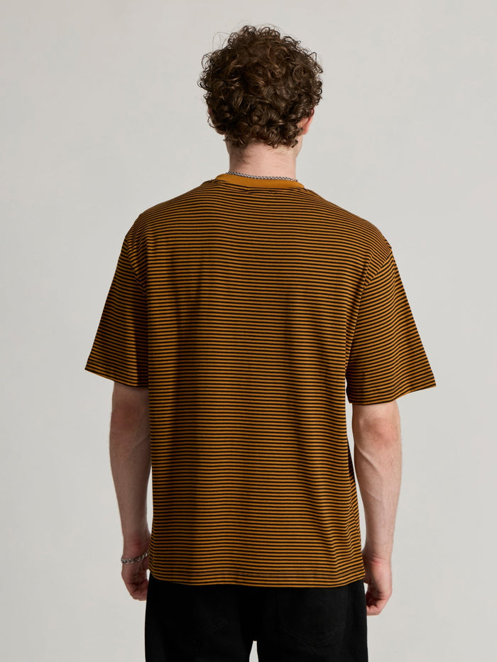 Man wearing a mustard yellow and black striped crew t-shirt