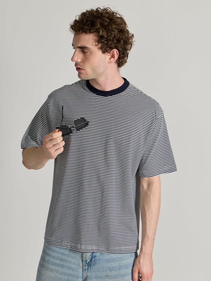 Man wearing a navy blue striped crew t-shirt