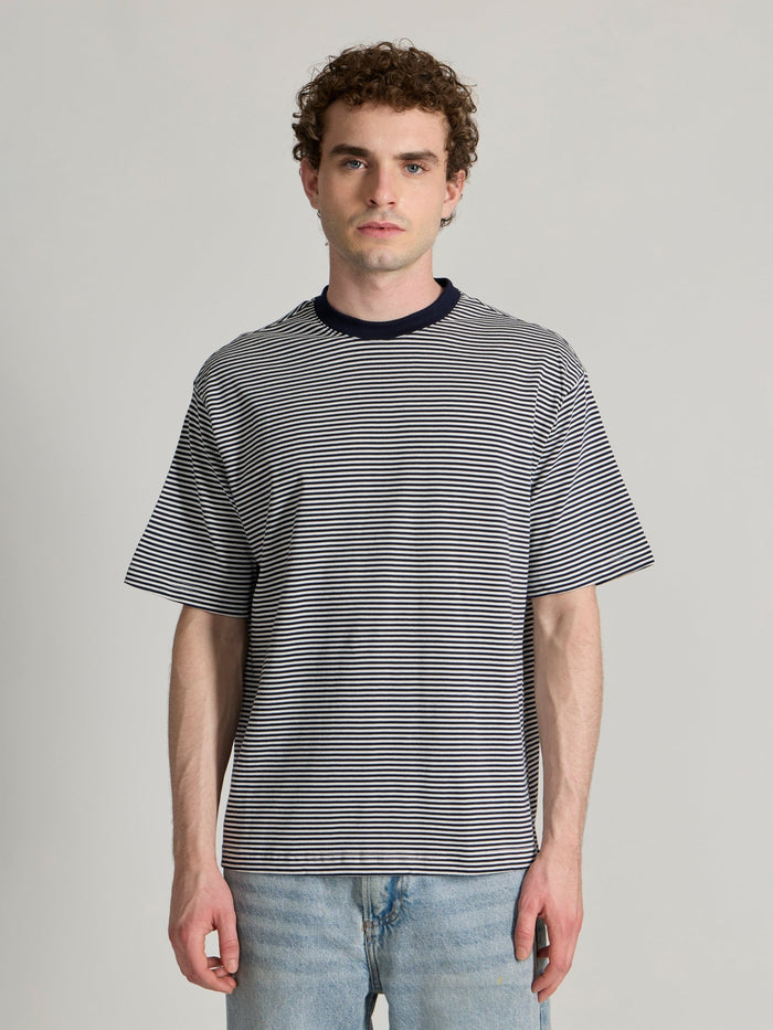 Man wearing a navy blue striped crew t-shirt