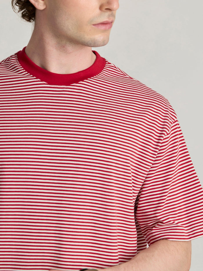 Man wearing a pink and white striped crew t-shirt