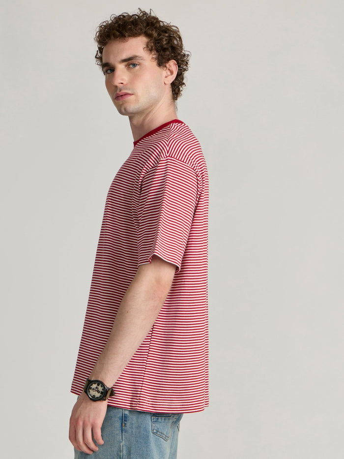 Man wearing a pink and white striped crew t-shirt