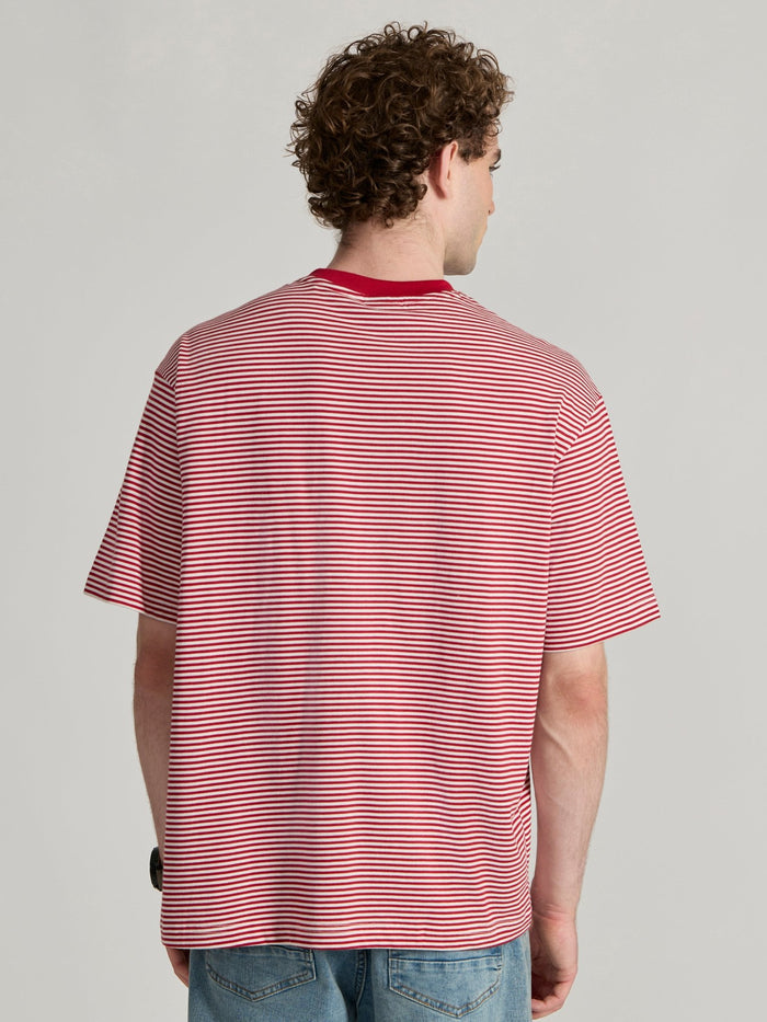 Man wearing a pink and white striped crew t-shirt