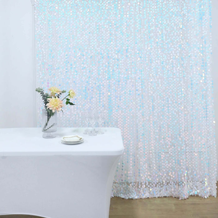 Elegant table setup with flowers and glassware against a shimmering backdrop.