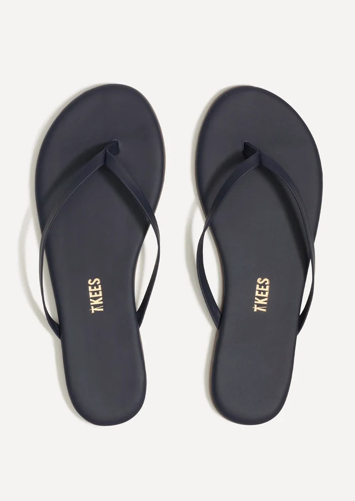 A pair of leather skinny strap TKEES sandals in dark navy.