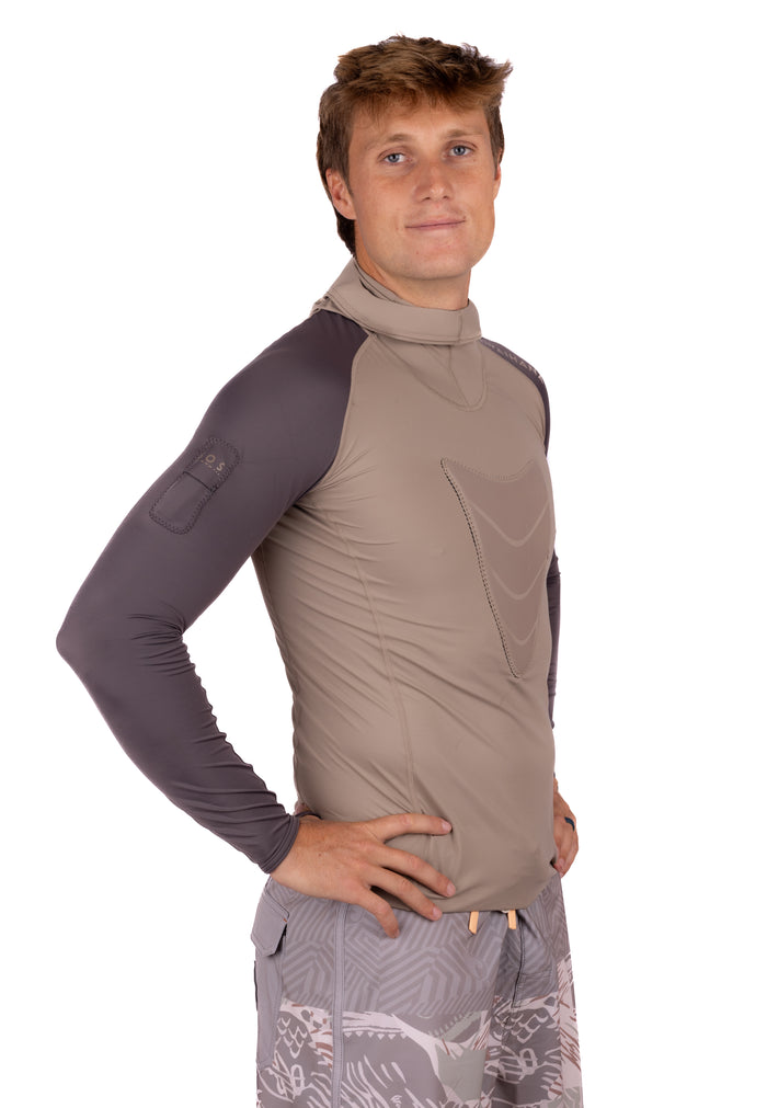 Male model wearing the Waihana Mana Hooded Spearfishing Rashguard in tan and dark grey, featuring a mock neck hood, contrast sleeves, and a chest pocket detail, shown from a three-quarter angle.