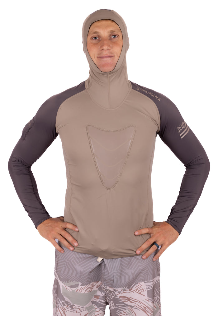 Male model wearing the Waihana Mana Hooded Spearfishing Rashguard in tan and charcoal, featuring a full hood, long dark sleeves, and a chest load pad, photographed against a white background.