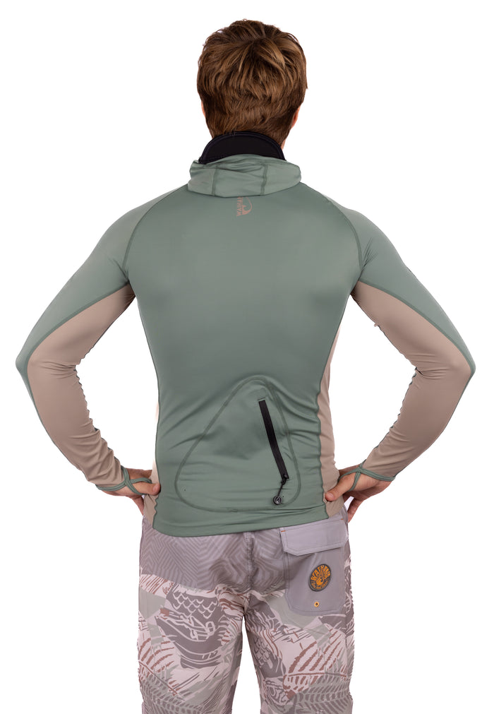 Back view of a male model wearing the Waihana Olive Hooded Voyager Rashguard in green and tan colorblock with a rear zip pocket, paired with patterned board shorts.