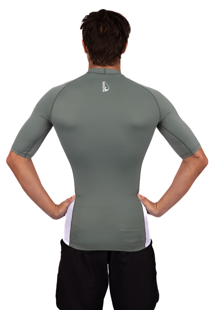 Back view of a male model wearing a fitted olive short-sleeve Waihana rashguard with white side panels and the Waihana logo on the upper back.