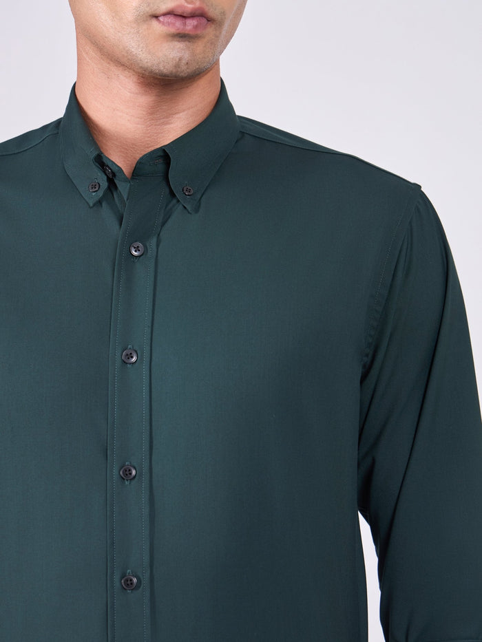 Man wearing Tencel  prussian blue shirt and light gray pants on a white background