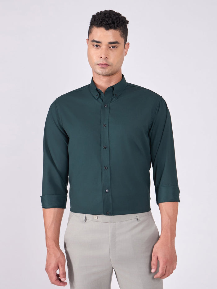 Man wearing Tencel  prussian blue shirt and light gray pants on a white background