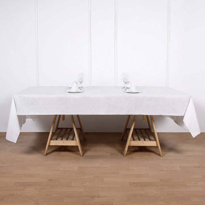 White tablecloth draped over a wooden table with dining setup.
