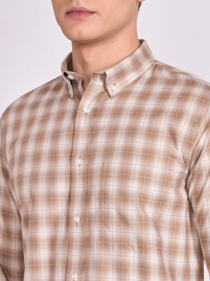 Man wearing a brown  checkered shirt.