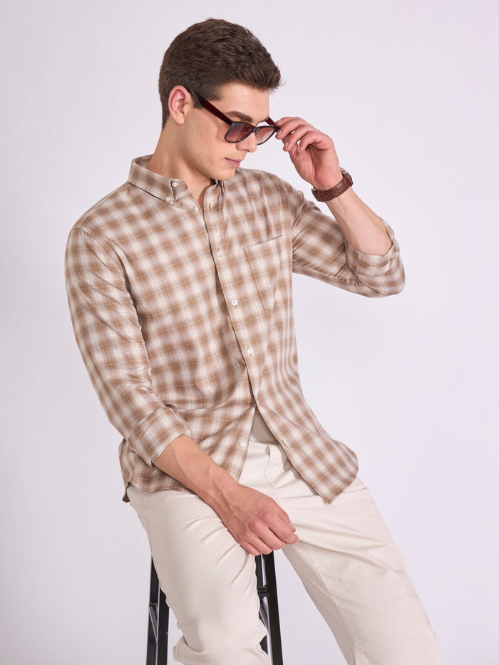Man wearing a brown  checkered shirt.