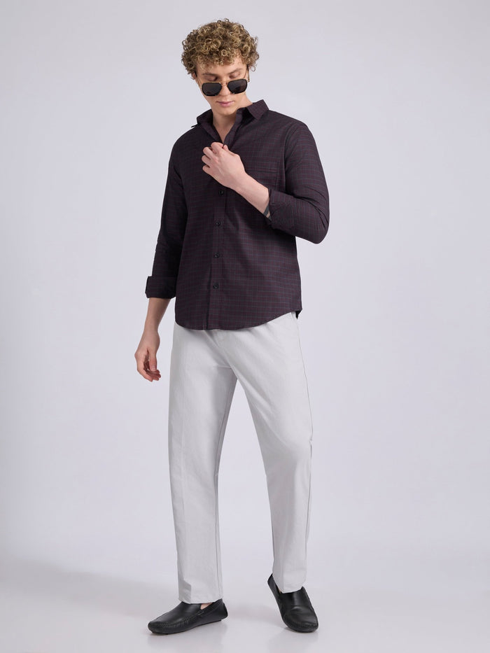 Man wearing a dark burgundy checkered shirt.
