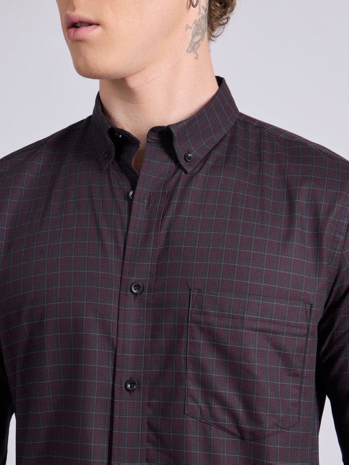 Man wearing a dark burgundy checkered shirt.