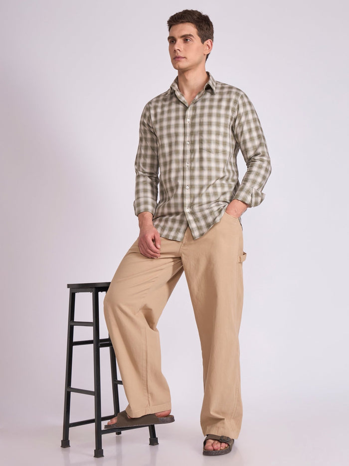 Man wearing a Olive green checkered shirt.