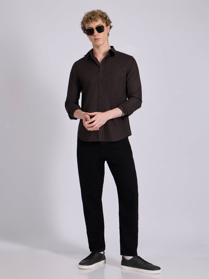 Man wearing a dark brown micro checkered shirt .