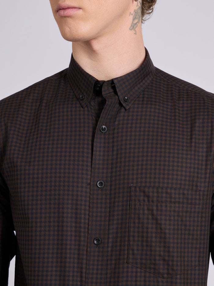 Man wearing a dark brown micro checkered shirt .