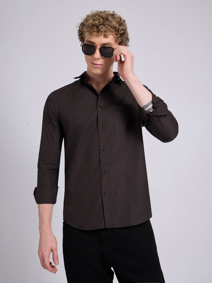 Man wearing a dark brown micro checkered shirt .