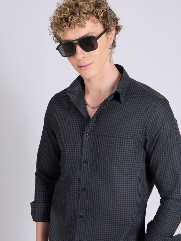 Man wearing a dark steel blue micro checkered shirt .