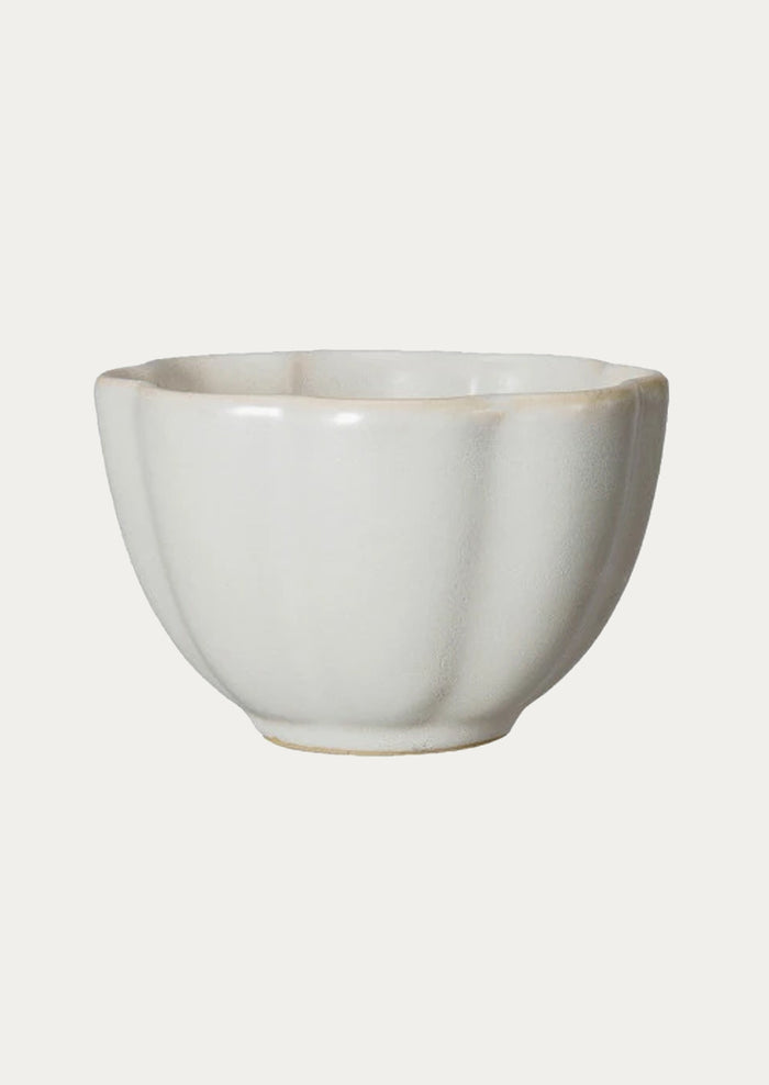 A ceramic snack bowl with scalloped shape in ivory.