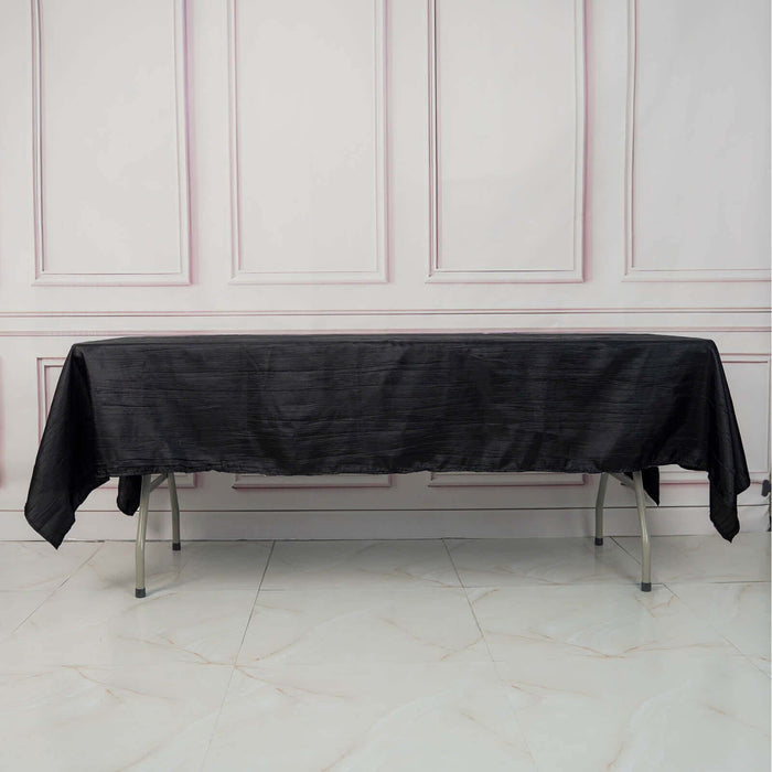 Black tablecloth draped on a folding table in a studio setting.