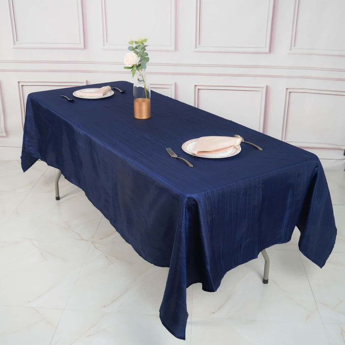 Navy blue tablecloth on a dining table set for two with elegant decor.