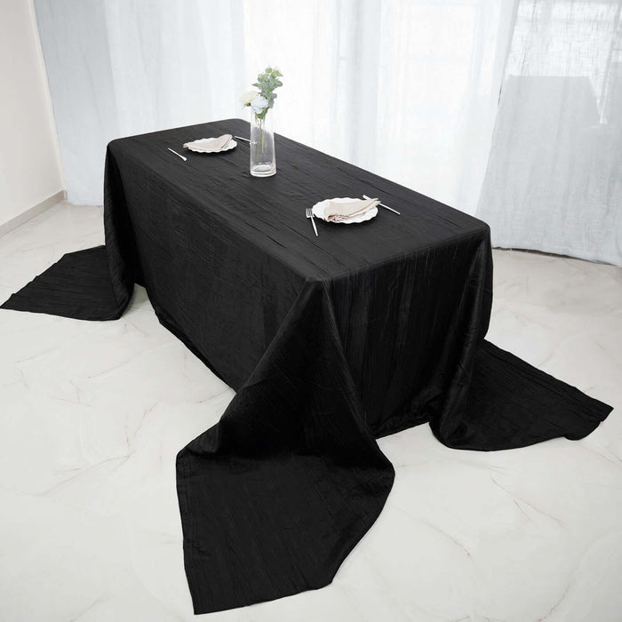Elegant black tablecloth draped on a dining table with plates and chopsticks.