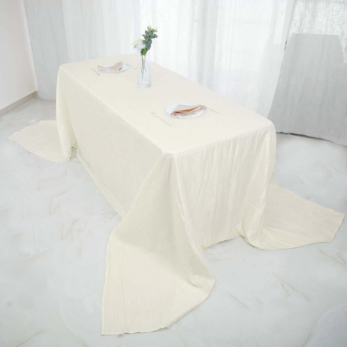 Elegant cream tablecloth draped on a dining table with floral centerpiece.