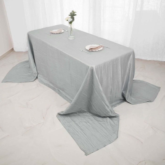 Elegant gray tablecloth draped over a dining table with floral centerpiece.