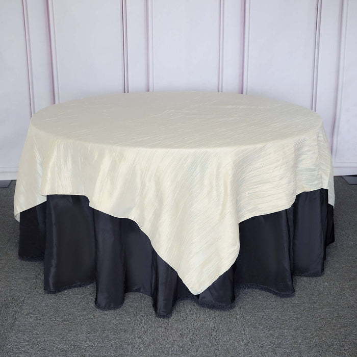 Cream tablecloth with black ruffled trim on an oval table.